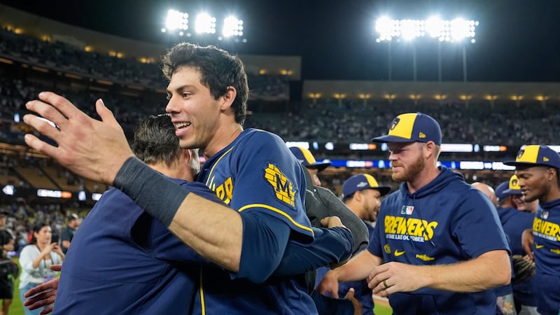 Milwaukee Brewers designated hitter Christian Yelich celebrates with teammates after Game 4 of...