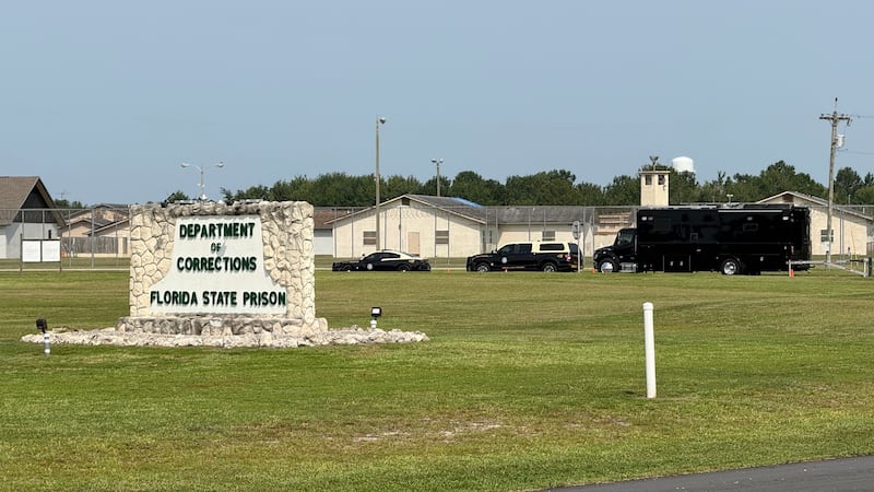 FILE - Law enforcement vehicles sit parked outside the Florida state prison in Starke, Fla.,...