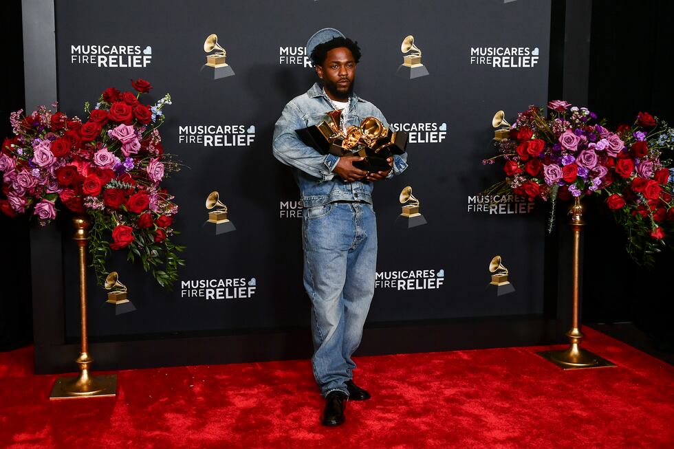 Kendrick Lamar poses in the press room with the award for record of the year, best rap...